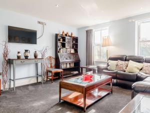 a living room with a couch and a table at Claysun House in Whitecroft