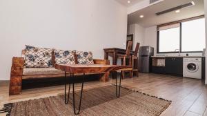 uma sala de estar com um sofá e uma mesa em Tanzanite Serviced Apartment - TSA Masaki em Dar es Salaam
