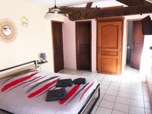 a bedroom with a bed with red and white sheets at Maison " Elixondoa " in Pagolle