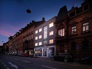 un edificio en una calle con coches aparcados delante en Boarding World Heidelberg en Heidelberg