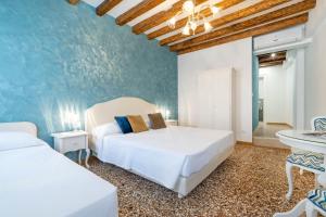 1 dormitorio con 2 camas y pared azul en Residenza San Silvestro, en Venecia