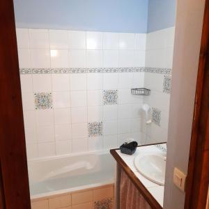 a bathroom with a tub and a sink at Maison " Elixondoa " in Pagolle