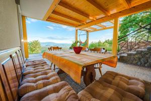 una mesa y sillas en un porche con una gran ventana en Villa Zupan with Hot Tub, en Škocjan