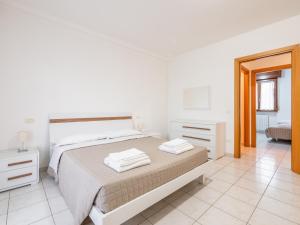 Habitación blanca con cama y espejo en Ca' Mastro Bright Flat with parking, en Tavullia