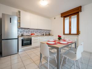 cocina con mesa, sillas y nevera en Ca' Mastro Bright Flat with parking, en Tavullia