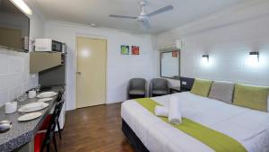 a bedroom with a large bed and a table and chairs at Azalea Motel in Coonabarabran