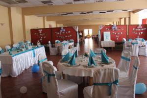 un salón de banquetes con mesas blancas y sillas azules en Hotel Slodes en Belgrado