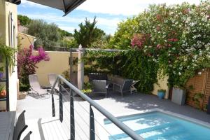 a balcony with a swimming pool and flowers at Jolie Villa, Piscine, 10min centre ville, WIFI in Montpellier