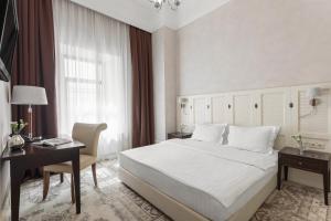 sypialnia z dużym białym łóżkiem, biurkiem i biurkiem w obiekcie Ribas Duke Boutique Hotel w Odessie