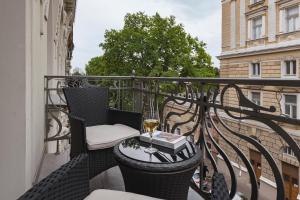 a balcony with a table and a glass of wine at Ribas Duke Boutique Hotel in Odesa