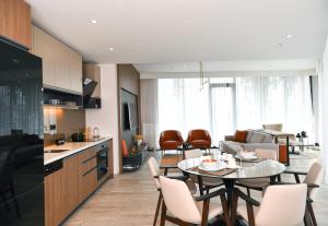 WestSide Residences by Rotana في إسطنبول: مطبخ وغرفة معيشة مع طاولة وكراسي