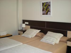 a bedroom with a bed with two pillows on it at Hotel MR in Tarragona