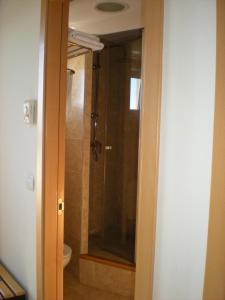 
a bathroom with a door open and a shower stall at Hotel MR in Tarragona
