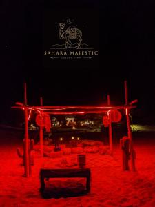 scena z czerwonymi światłami w piasku w nocy w obiekcie Sahara Majestic Luxury Camp w mieście Merzouga