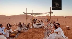 a group of people sitting in the desert at Sahara Majestic Luxury Camp in Merzouga