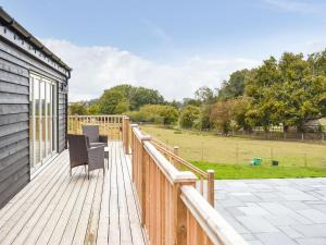 a deck with two chairs and a view of a field at Deerson Barn in Wingham