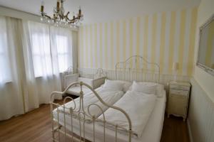 a bedroom with a white bed and a chandelier at Landhaus Hamm in Düsseldorf