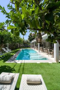 einen Pool in einem Garten mit Stühlen und einem Haus in der Unterkunft Hotel Rivage Taormina in Taormina
