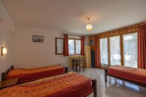 a bedroom with two beds and a table and chairs at Le petit chez soi in Châtel