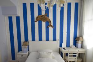 1 dormitorio con cama y pared de rayas azul y blanco en Landhaus Hamm en Düsseldorf