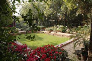 a garden with a lawn with flowers and plants at Devi Bhawan - A Heritage Hotel in Jodhpur