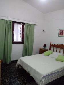 a bedroom with two beds and a window with green curtains at BELACHA - Casa de Playa in Costa Azul +14 photos