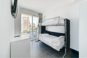 sypialnia z łóżkiem piętrowym i oknem w obiekcie Hotel Brisa w mieście Benidorm