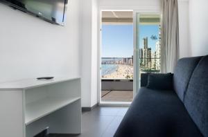a living room with a couch and a view of the beach at Hotel Brisa in Benidorm