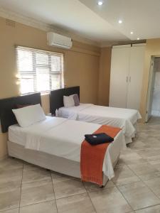 two beds in a room with twoermottermott at Mavundla guest house in Richards Bay