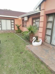 a swan statue in the yard of a house at Mavundla guest house in Richards Bay