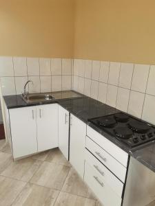 a white kitchen with a sink and a stove at Mavundla guest house in Richards Bay