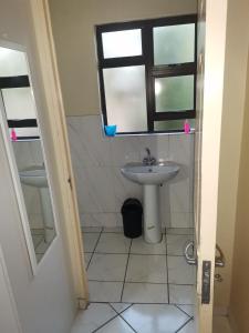 La salle de bains est pourvue d'un lavabo et d'une fenêtre. dans l'établissement Mavundla guest house, à Richards Bay
