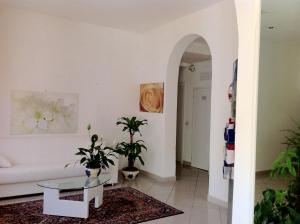 Residence Villa Ofelia في ريميني: غرفة معيشة مع أريكة بيضاء وطاولة
