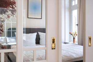 a bedroom with a white bed and a window at Altstadt Apartments Verden in Verden