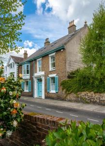 a brick house with a blue door on a street at Bear's Well Bed & Breakfast in Deal