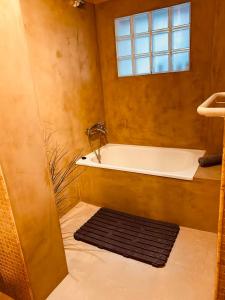 een badkamer met een bad, een raam en een tapijt bij BEACH HOUSE ! in Tarifa