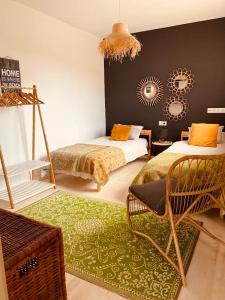 1 dormitorio con 2 camas, silla y alfombra en BEACH HOUSE ! en Tarifa