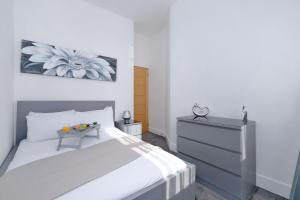 a bedroom with a bed and a dresser with a table at Orange Apartments Union Grove in Aberdeen