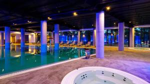 a swimming pool with chairs in a building at Laurasapartment in Jarosławiec