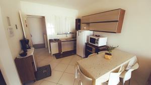 eine kleine Küche mit einem Tisch und einem Kühlschrank in der Unterkunft Casa_Margarida in Penha