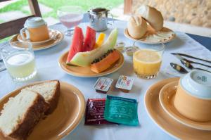 a table with plates of food and fruit on it at Pousada Brazish in Paraty