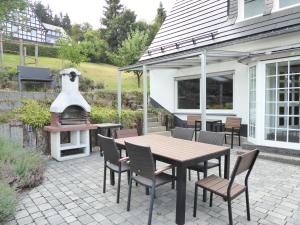 eine Terrasse mit einem Tisch, Stühlen und einem Grill in der Unterkunft Family Mountain Winterberg Chalet privates Haus 10 Pers 4 Schlafzimmer WiFi near Lift in Winterberg