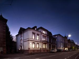 ein weißes Haus in der Nacht auf einer Stadtstraße in der Unterkunft Boarding World Heidelberg in Heidelberg