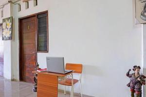 einen Laptop auf einem Schreibtisch mit Stuhl in der Unterkunft OYO Life 91670 Mannsur Homestay Syariah in Sidoarjo