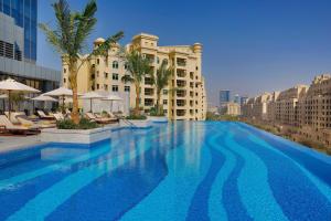 Luxury Living & Views -St Regis High Floor Suite 4 by Exclusive Holiday Homes في دبي: مسبح كبير امام مبنى