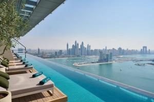 Luxury Living & Views -St Regis High Floor Suite 4 by Exclusive Holiday Homes في دبي: مسبح لا متناهي تابع للفندق مطل على المدينة