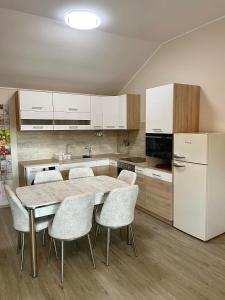 a kitchen with a table and chairs and a refrigerator at Moonlight Apartment in Siófok