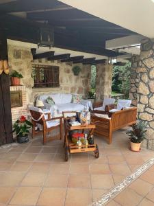 un patio con sofá, sillas y mesa en Casa Rural LOS TINES, en Bustarviejo