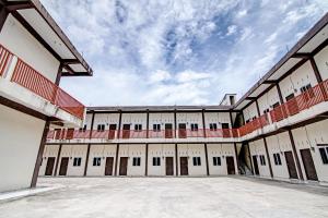 an empty building with a cloudy sky in the background at SPOT ON 91699 Homestay Hj Lela Syariah in Pekanbaru