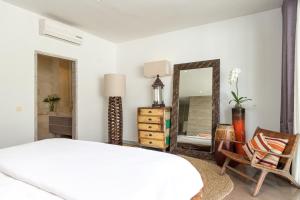 1 dormitorio con cama, espejo y silla en Villa Mia, en Canggu